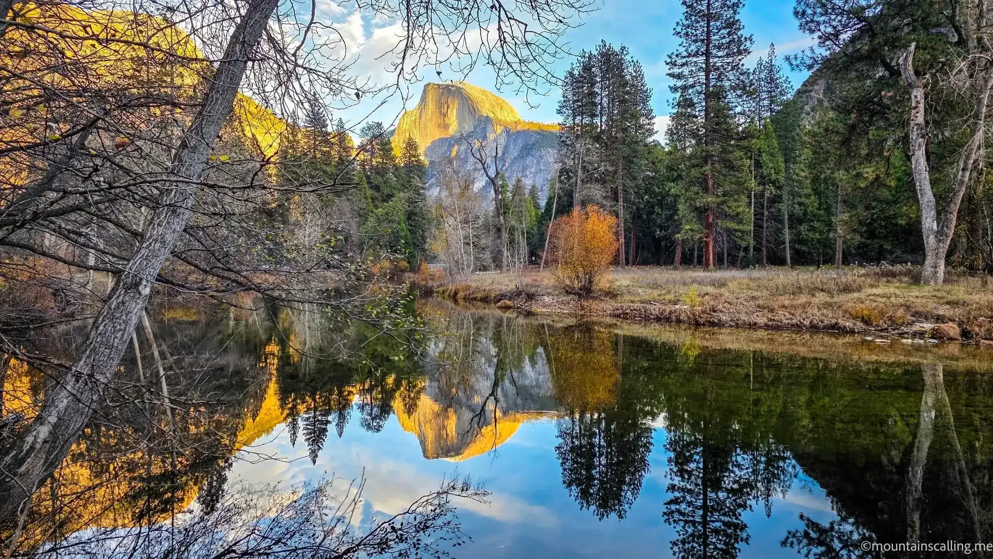 Half Dome and Yosemite Valley autumn reflection in Merced River with golden light on granite cliffs