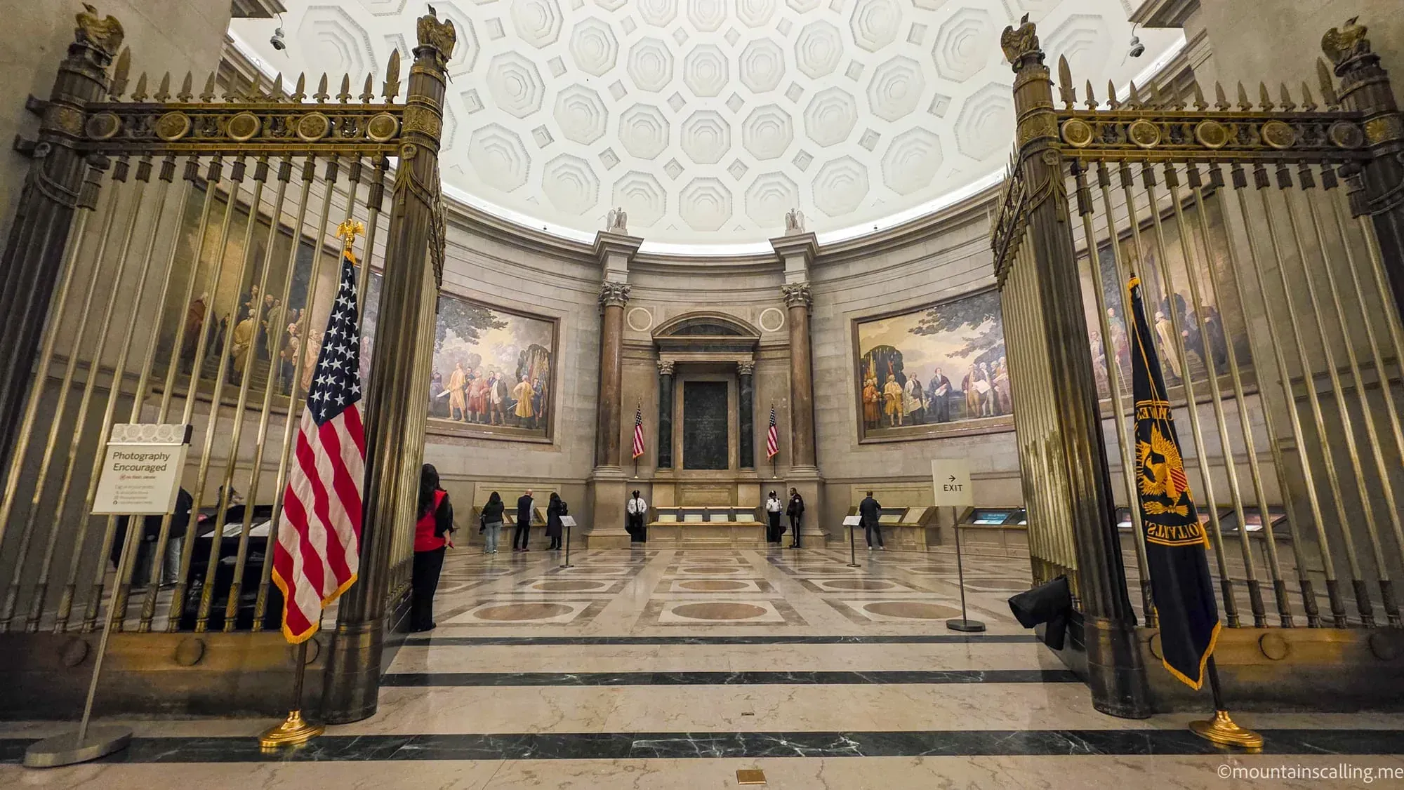 National Archives Rotunda displaying the Constitution behind protective glass with ornate bronze gates and domed ceiling