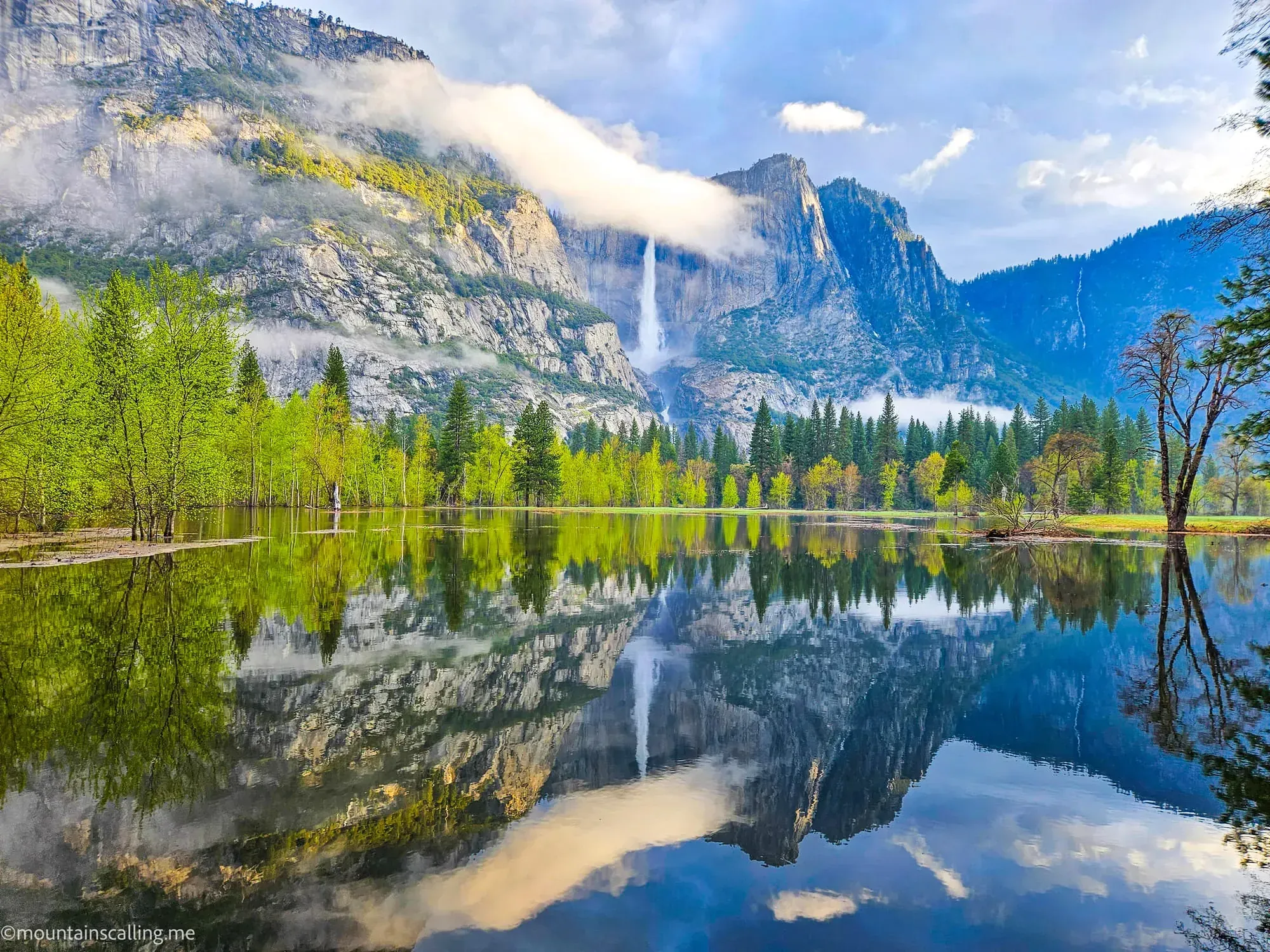 Yosemite Falls and granite cliffs perfectly mirrored in flooded Merced River waters in Yosemite Valley