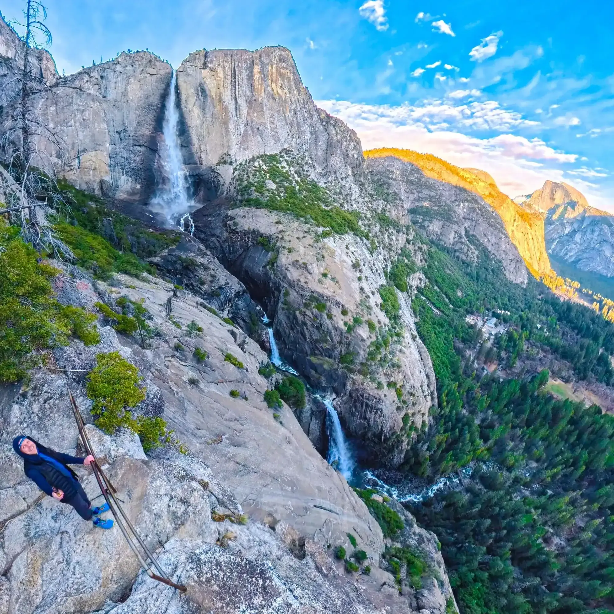 Hiker at the top of Yosemite Falls overlooking the Valley and Half Dome at sunset