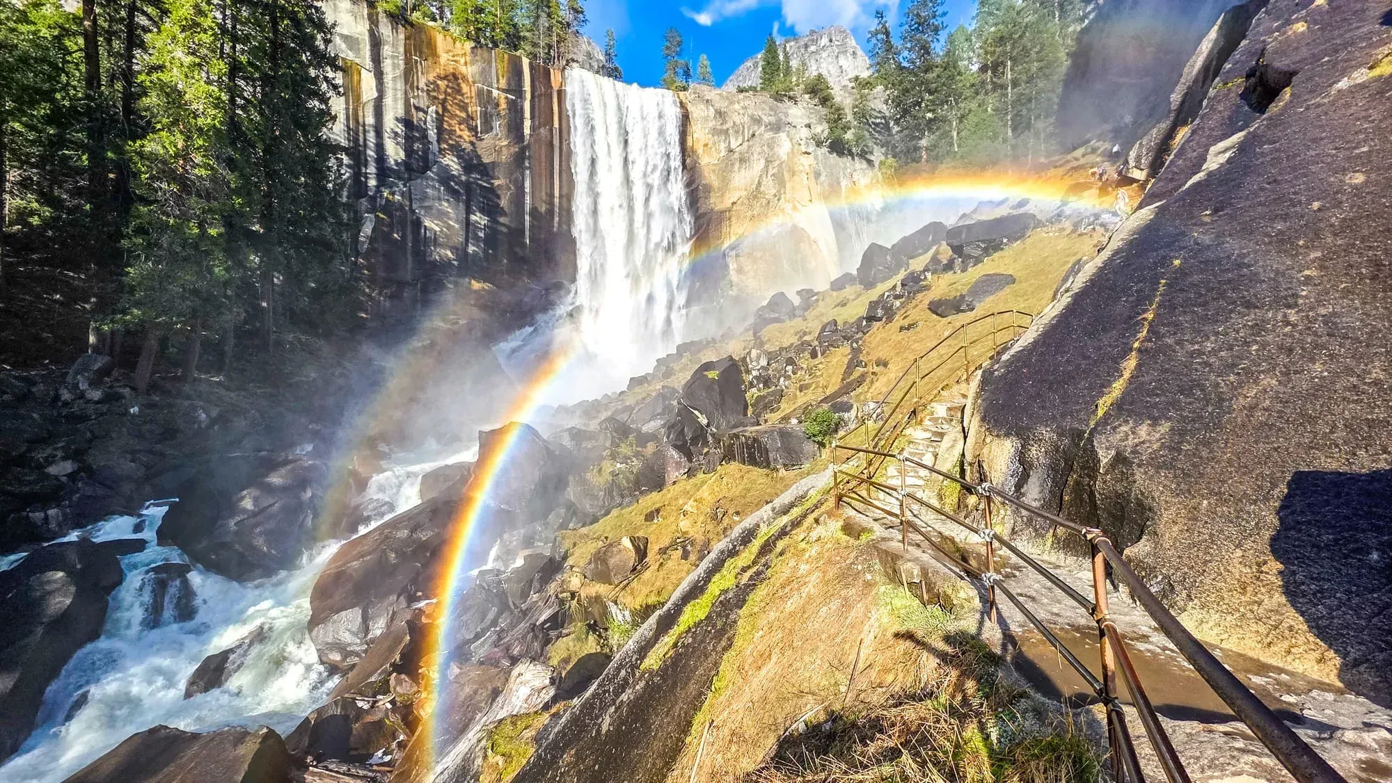 Rainbow arcs through mist at Vernal Fall during guided Yosemite day hike