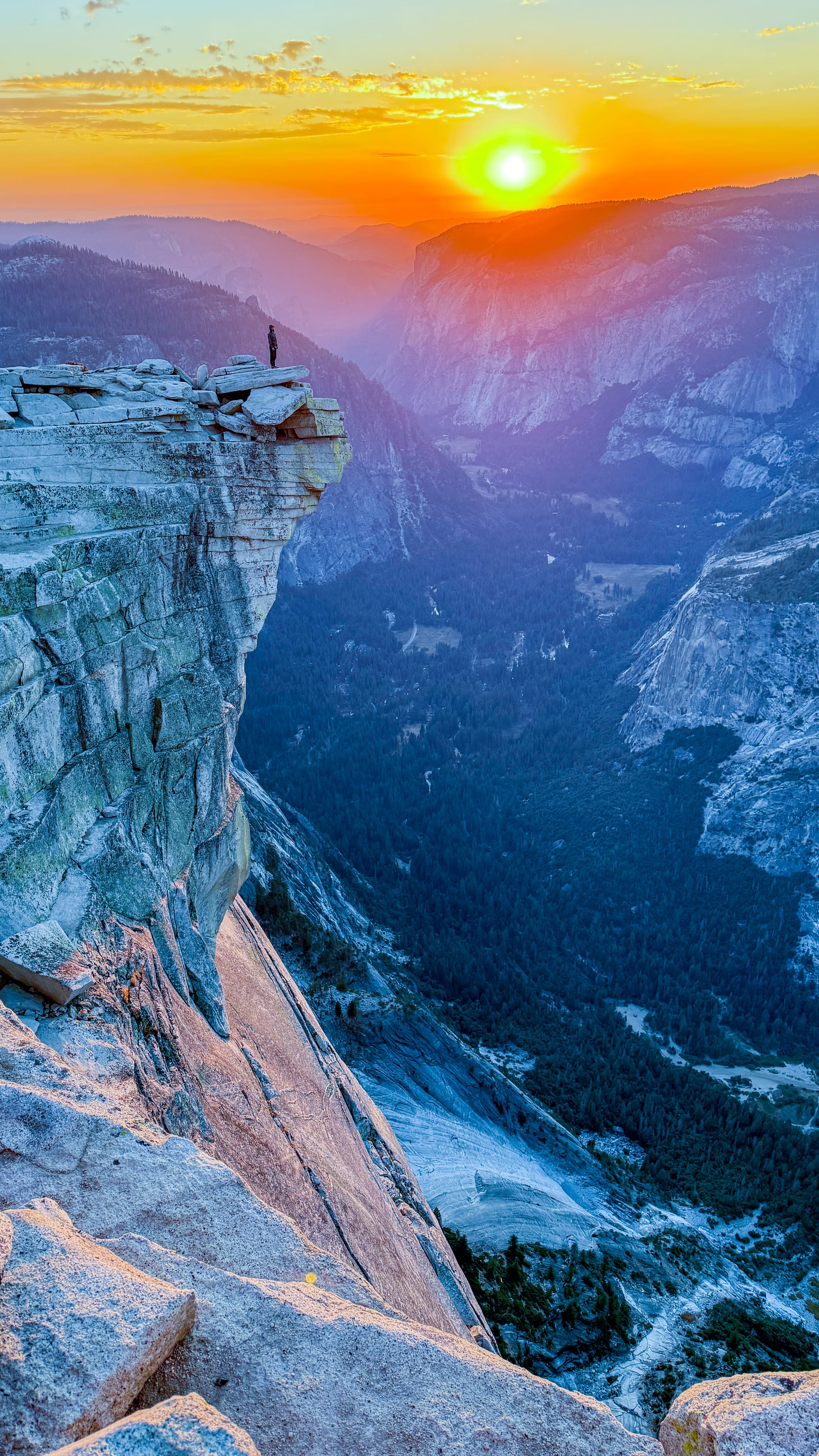 Hiker standing on The Visor of Half Dome at sunset with Yosemite Valley far below | Yosemite Life