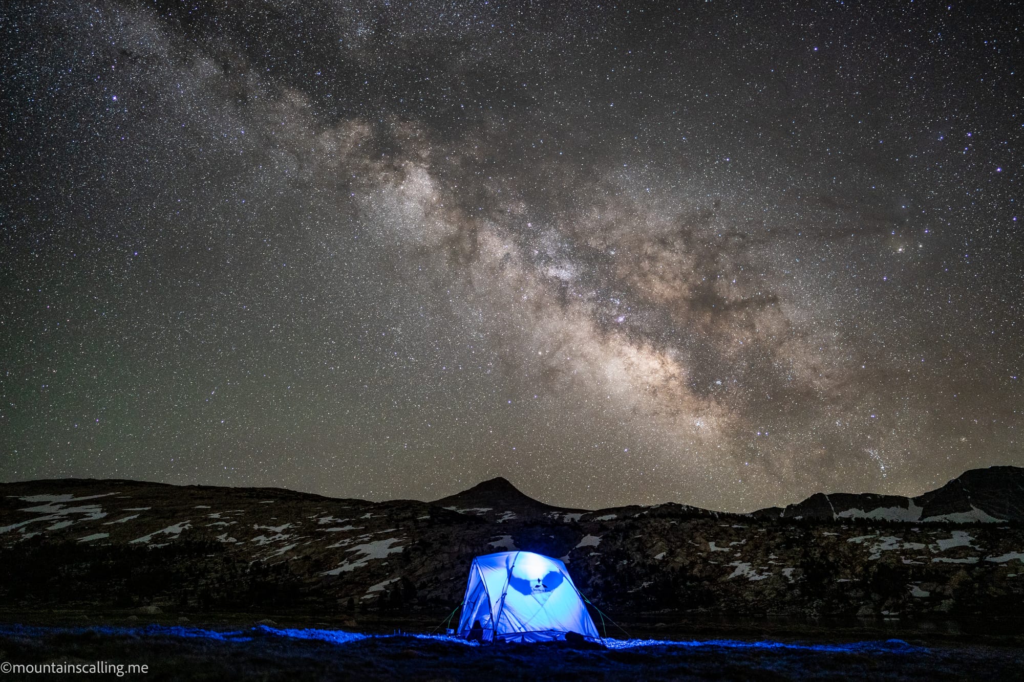 Galactic Center of Milky Way Galaxy over a blue-lit tent in Yosemite National Park high country.